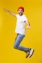 Young casual man jumping for joy on yellow gold background Royalty Free Stock Photo