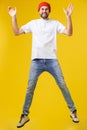 Young casual man jumping for joy on yellow gold background Royalty Free Stock Photo