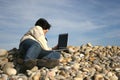 Young casual man with laptop at the beach Royalty Free Stock Photo