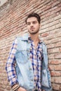 Young casual man leaning on a brick wall Royalty Free Stock Photo