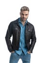 Young casual man in leather jacket holding hands in pockets