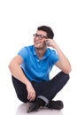 Young casual man sitting and talking on his cell phone Royalty Free Stock Photo