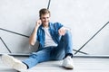 Young casual man talking on the phone while lying on the floor. Royalty Free Stock Photo