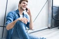 Young casual man talking on the phone while lying on the floor. Royalty Free Stock Photo