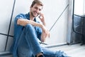 Young casual man talking on the phone while lying on the floor. Royalty Free Stock Photo