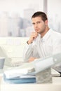 Young casual office worker sitting at desk Royalty Free Stock Photo