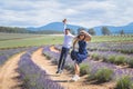 Young casual trendy boy and girl jumping at lavender field. Blue cloud summer daytime. Royalty Free Stock Photo