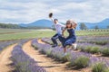 Young casual trendy boy and girl jumping at lavender field. Blue cloud summer daytime. Royalty Free Stock Photo