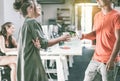 Young casually dressed co-workers having a break drinking coffee - Trendy teamwork in creative office - Focus on guys faces and Royalty Free Stock Photo