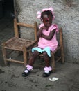 Young Catholic kindergarten school girl sits outside.