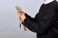 A young Catholic pastor counts dollars after the service. Corruption in Christianity and Catholicism