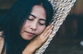 Young caucasian asian girl swinging in a hammock in a pleasant laziness of a weekend evening.