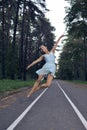 Sexy Slim Young Caucasian Ballet Dancer in Light Blue Tutu Posing in Jumping Dance Pose During Ballet Pas in Summer Forest With Royalty Free Stock Photo