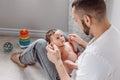 Young Caucasian bearded father dad holding newborn baby son daughter