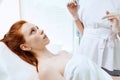 Caucasian red-haired woman gets beauty facial injections. Face aging injection. Royalty Free Stock Photo