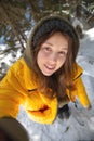 Young Caucasian beautiful woman smiling. Taking a selfie photo with a camera in winter, in a snowy forest. Girl outdoors Royalty Free Stock Photo