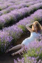 Young caucasian beautiful woman in a white dress smelling flowers in a lavender field Royalty Free Stock Photo