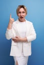 young caucasian blond lady in white jacket and dress holding thumbs up Royalty Free Stock Photo