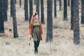 Young Caucasian blonde woman in autumn wreath walking in the pine forest Royalty Free Stock Photo