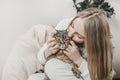 Young caucasian blonde woman hugging and kissing her brown tabby cat Royalty Free Stock Photo