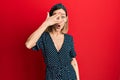 Young caucasian blonde woman wearing beautiful black and white dress peeking in shock covering face and eyes with hand, looking Royalty Free Stock Photo