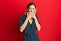 Young caucasian blonde woman wearing beautiful black and white dress shocked covering mouth with hands for mistake Royalty Free Stock Photo