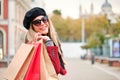 Young caucasian woman wearing sunglasses holding shopping bags in winter. Royalty Free Stock Photo