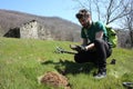 Young caucasian boy dressed in solid camouflage. man looking for treasures buried underground with his metal detector