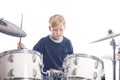 Young caucasian boy at drum kit in studio plays music Royalty Free Stock Photo