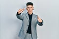 Young caucasian boy with ears dilation wearing business jacket approving doing positive gesture with hand, thumbs up smiling and Royalty Free Stock Photo