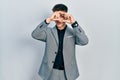 Young caucasian boy with ears dilation wearing business jacket doing heart shape with hand and fingers smiling looking through Royalty Free Stock Photo