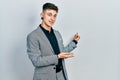 Young caucasian boy with ears dilation wearing business jacket inviting to enter smiling natural with open hand Royalty Free Stock Photo