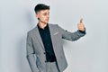 Young caucasian boy with ears dilation wearing business jacket looking proud, smiling doing thumbs up gesture to the side Royalty Free Stock Photo