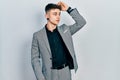 Young caucasian boy with ears dilation wearing business jacket smiling confident touching hair with hand up gesture, posing Royalty Free Stock Photo