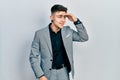 Young caucasian boy with ears dilation wearing business jacket very happy and smiling looking far away with hand over head Royalty Free Stock Photo