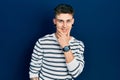 Young caucasian boy with ears dilation wearing casual striped shirt looking confident at the camera smiling with crossed arms and Royalty Free Stock Photo