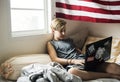 Young caucasian boy lying using computer laptop on bed Royalty Free Stock Photo