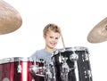 young caucasian boy plays drums in studio against white background Royalty Free Stock Photo