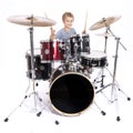 young caucasian boy plays drums in studio against white background Royalty Free Stock Photo