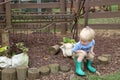 Young caucasian boy sitting on a stump in a garden Royalty Free Stock Photo