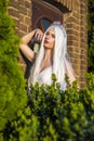 Young Caucasian Bride with Long White Hair Posing Against Old Brick Building Outdoors Royalty Free Stock Photo