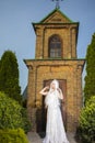 Young Caucasian Bride with Long White Hair Posing Against Old Brick Church Outdoors Royalty Free Stock Photo