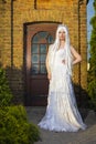 Young Caucasian Bride with Long White Hair Posing Against Old Brick House Outdoors Royalty Free Stock Photo