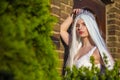 Young Caucasian Bride with Tiara and Long White Hair Posing Against Old Brick Wall  Outdoors Royalty Free Stock Photo