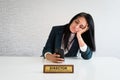 Young caucasian brunette business woman director in office sit at desk use phone scroll news social media bored at work director Royalty Free Stock Photo