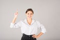 The businesswoman points her finger up at the copy space for advertising on a gray background Royalty Free Stock Photo