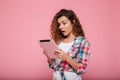 Young caucasian brunette lady using tablet computer isolated over pink Royalty Free Stock Photo