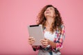 Young caucasian brunette lady using tablet computer isolated over pink Royalty Free Stock Photo