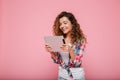 Young caucasian brunette lady using tablet computer isolated over pink Royalty Free Stock Photo