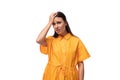 young caucasian brunette woman with long hair dressed in a yellow summer dress is trying to remember something important Royalty Free Stock Photo